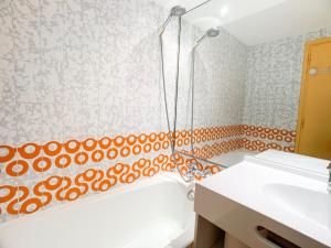 a bathroom with an orange and white shower curtain at Proche commerces et pistes · Appartement lumineux avec balcon · 2 pièces pour 6 personnes - FR-1-502-503 in Tignes +6 photos