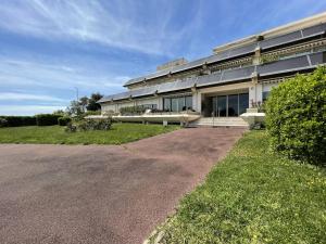 un grand bâtiment avec une route devant lui dans l'établissement Appartement La Rochelle, 1 pièce, 2 personnes - FR-1-246-658, à La Rochelle