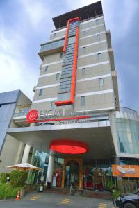 un edificio alto con una señal roja delante de él en @Hom Semarang Simpang Lima en Semarang