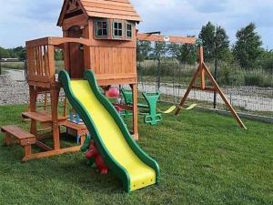 un parque infantil con tobogán y una casa de juegos en Comfortable holiday homes for 7 people, Niechorze, en Niechorze