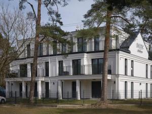 a white building with a balcony on top of it at A comfortable apartment with a garden for 2 people Pobierowo in Pobierowo