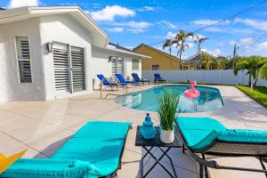 a patio with a pool and chairs and a house at Private Pool｜Near Beach｜Fenced Yard｜Outdoor Living in Naples