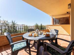 - une table et des chaises sur un balcon avec de la nourriture dans l'établissement Eden Golf Sur - Southfacing Apartment, à Mijas