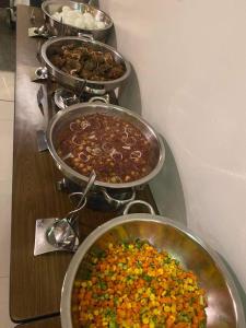 une rangée de pots remplis de différents types de denrées alimentaires dans l'établissement Summit Hotel Magnolia, à Manille