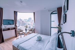 胡志明市Mint Hotel Bui Vien Q1的一间带床和大窗户的酒店房间