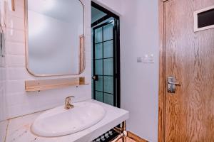 胡志明市Mint Hotel Bui Vien Q1的带白色水槽和镜子的浴室 更多56张照片