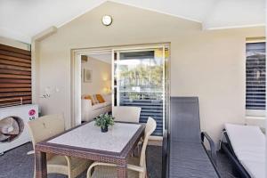 a kitchen and living room with a table and chairs at Oaks Pacific Blue Pool spa more in complex in Salamander Bay