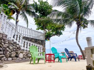 un grupo de sillas coloridas sentadas junto a una pared en Oceanside Villa @ Ocho Rios, Jamaica Getaway en Boscobel