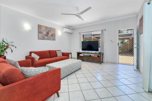 a living room with a couch and a tv at OFFLINE - Charming 3BR Retreat in Central Location of Darwin in Stuart Park