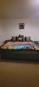 a large bed with a colorful blanket on it at Cozy Comforts 2 bed apartment Central Warrington in Warrington