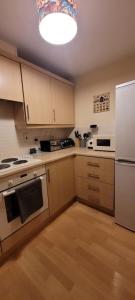 eine Küche mit weißen Geräten und einem weißen Kühlschrank in der Unterkunft Cozy Comforts 2 bed apartment Central Warrington in Warrington
