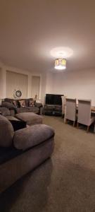 a living room with a couch and chairs and a table at Cozy Comforts 2 bed apartment Central Warrington in Warrington