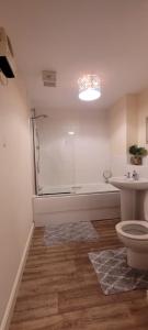 ein Badezimmer mit einer Badewanne, einem WC und einem Waschbecken in der Unterkunft Cozy Comforts 2 bed apartment Central Warrington in Warrington