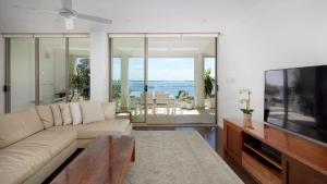 un soggiorno con divano e TV a schermo piatto di Aura 2 apartment with Spectacular Views a Shoal Bay