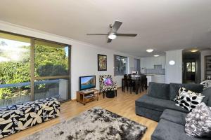 a living room with a couch and a dining room at Gorgeous Harbourside in Soldiers Point