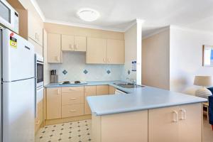 a kitchen with wooden cabinets and a blue counter top at Gorgeous Harbourside with Stunning views in Soldiers Point