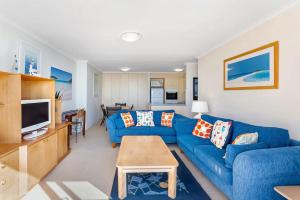 a living room with a blue couch and a table at Gorgeous Harbourside with Stunning views in Soldiers Point