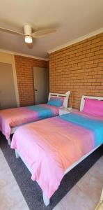 three beds are lined up in a room at Seaspray Walk to the beach in Nelson Bay