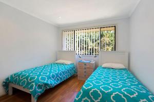 a bedroom with two beds and a window at Townhouse in the heart of Port Stephens in Salamander Bay