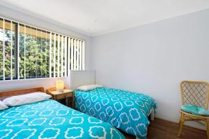 a bedroom with two beds and a window at Townhouse in the heart of Port Stephens in Salamander Bay