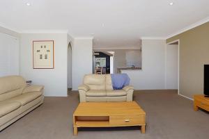 a living room with a couch and a coffee table at Views of Wanda Beach in Salamander Bay