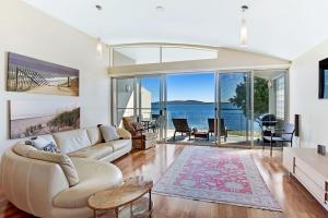 a living room with a couch and a view of the water at Breath Taking Waterfront in Corlette
