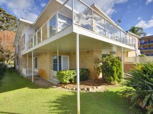 a house with a large balcony on a lawn at Beachside Shoal Bay Unit 6 in Shoal Bay