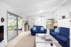 安娜湾Hidden Oasis Pet Friendly In Anna Bay的客厅里有两张蓝色沙发和一张桌子