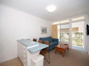 a living room with a blue couch and a table at Beachside Shoal Bay Unit 4 in Shoal Bay