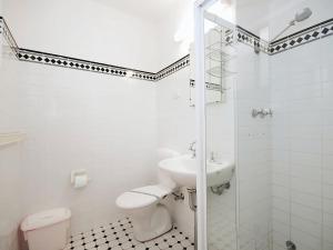 a white bathroom with a sink and a toilet at Beachside Shoal Bay Unit 4 in Shoal Bay
