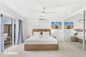 een witte slaapkamer met een bed en glazen wanden bij Osprey Waterfront Reserve Nelson Bay in Nelson Bay