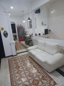 ein Wohnzimmer mit einer weißen Couch und einem Teppich in der Unterkunft HOSTEL M&H in Cartagena de Indias