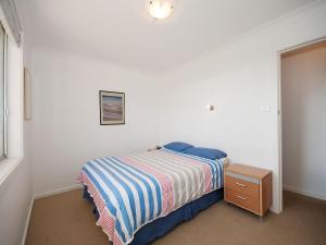 ein kleines Schlafzimmer mit einem Bett und einem Nachttisch in der Unterkunft Beachside Shoal Bay Unit 2 in Nelson Bay