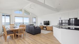 a kitchen and living room with a table and a couch at Absolute Waterfront Anna Bay in Anna Bay