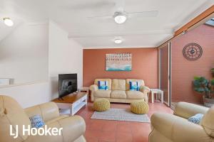 a living room with two couches and a tv at Amazing waterfront location in Soldiers Point