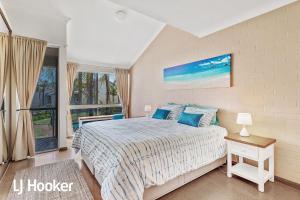 a bedroom with a bed and a large window at Amazing waterfront location in Soldiers Point +19 photos