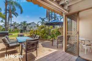 a patio with a table and chairs and an umbrella at Amazing waterfront location in Soldiers Point