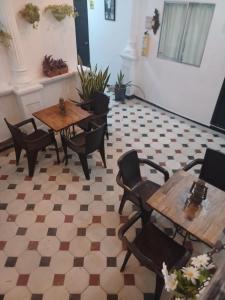 un restaurante con 2 mesas y sillas y una planta en HOSTEL M&H, en Cartagena de Indias