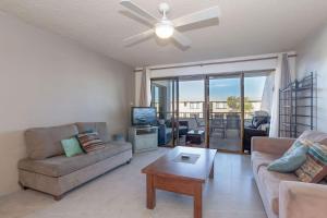 a living room with a couch and a ceiling fan at The Dunes Two bedroom apartment overlooking pool in Fingal Bay