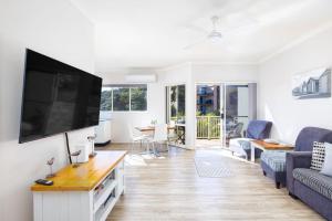 a living room with a large flat screen tv at Marty s Little Beach No 9 in Nelson Bay