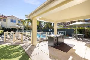 a patio with a grill and a swimming pool at Marty s Little Beach No 9 in Nelson Bay