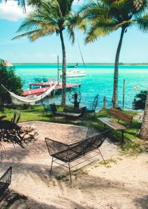 a group of benches and a boat on the water at Tortuga Bacalar in Bacalar