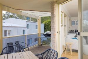 Habitación con balcón con mesa y sillas. en pet friendly - Views- Meters to the Beach & Anchorage Port Stephens, en Corlette