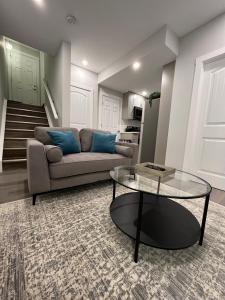 a living room with a couch and a glass table at Private Cozy Secondary Suite, 2 Bedrooms, Separate Entrance in Calgary