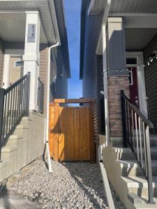 a house with a wooden gate and a door at Private Cozy Secondary Suite, 2 Bedrooms, Separate Entrance in Calgary