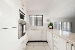 a white kitchen with white cabinets and a sink at Great Location in Nelson Bay in Nelson Bay