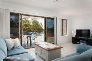 a living room with a blue couch and a tv at Great Location in Nelson Bay in Nelson Bay