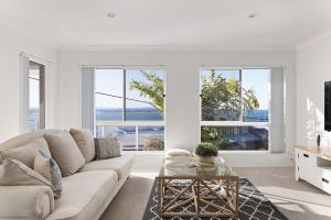 - un salon avec un canapé et une table dans l'établissement Tranquil with Harbour Views, à Nelson Bay