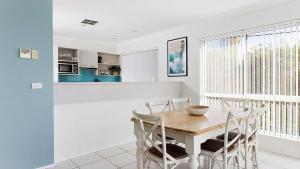 a kitchen and dining room with a wooden table and chairs at Tranquil with Harbour Views in Nelson Bay