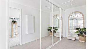 een witte kamer met glazen deuren en planten erin bij Tranquil with Harbour Views in Nelson Bay